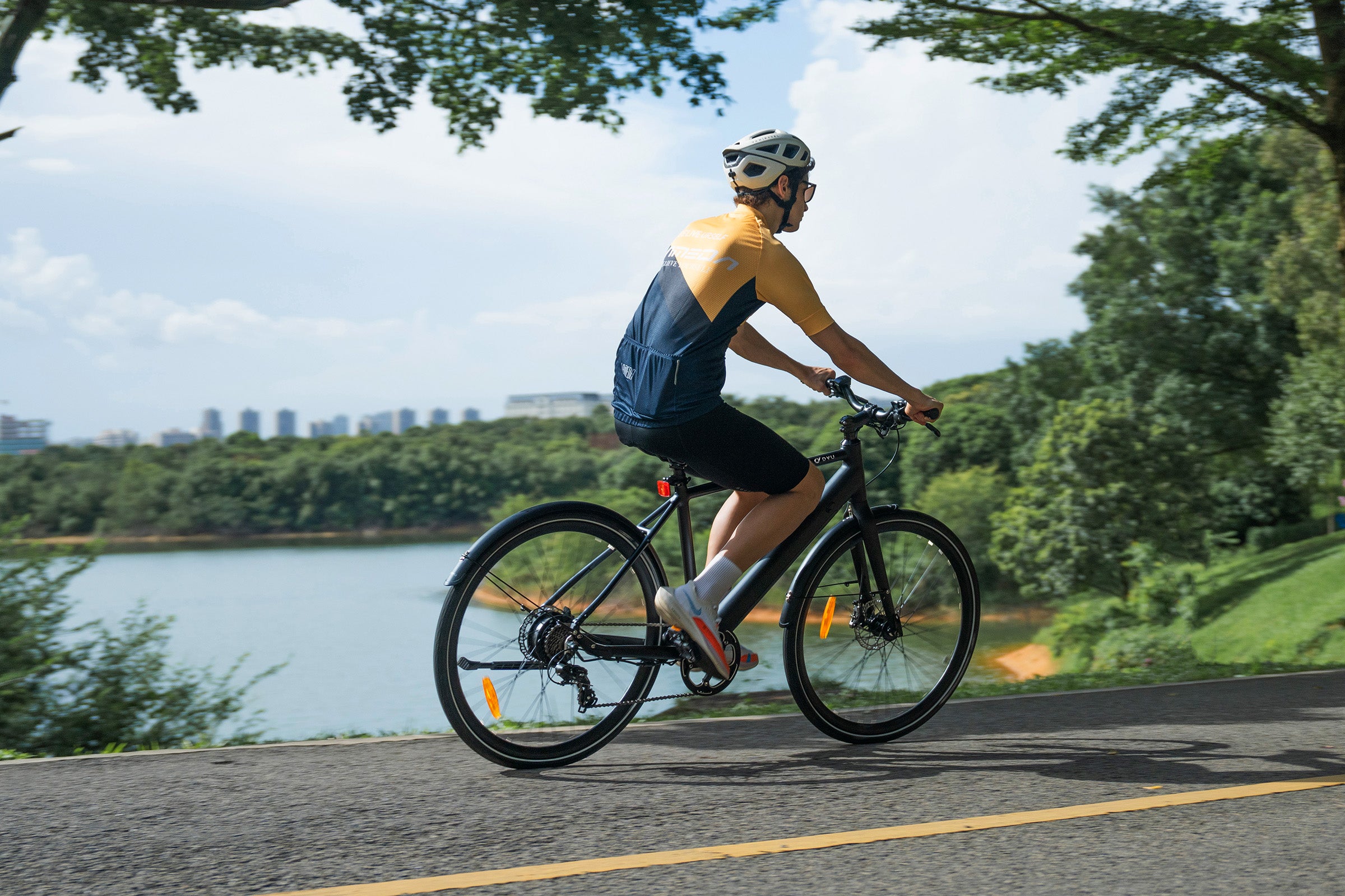 Uomo che pedala sulla bici elettrica DYU Stroll 1 vicino a un lago. Uomo che pedala sulla bici elettrica DYU Stroll 1 vicino a un lago.
