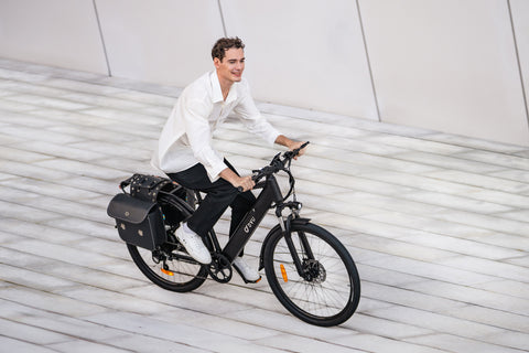 Uomo su bicicletta elettrica DYU C5 nera con portapacchi in ambiente urbano. Uomo su bicicletta elettrica DYU C5 nera con portapacchi in ambiente urbano.