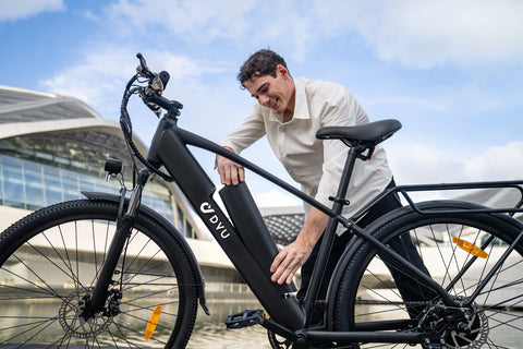 Uomo rimuove la batteria dalla bicicletta elettrica DYU C5 in ambiente urbano. Uomo rimuove la batteria dalla bicicletta elettrica DYU C5 in ambiente urbano.
