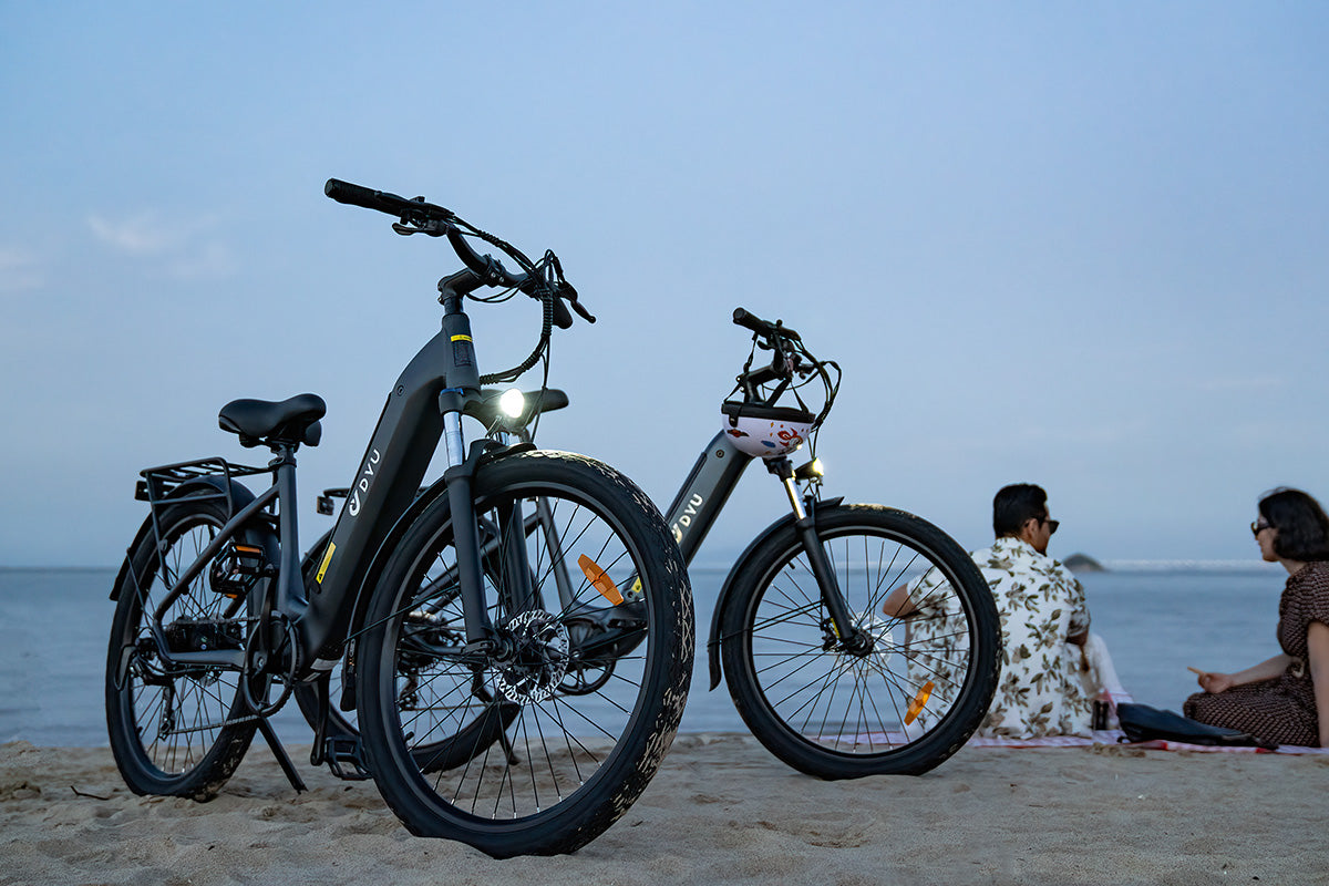 Biciclette elettriche DYU C1 grigie sulla spiaggia, ideali per spostamenti urbani. Biciclette elettriche DYU C1 grigie sulla spiaggia, ideali per spostamenti urbani.