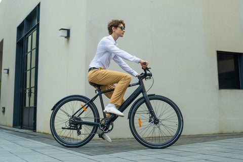 Uomo che pedala sulla bicicletta elettrica DYU Stroll 1 in città.