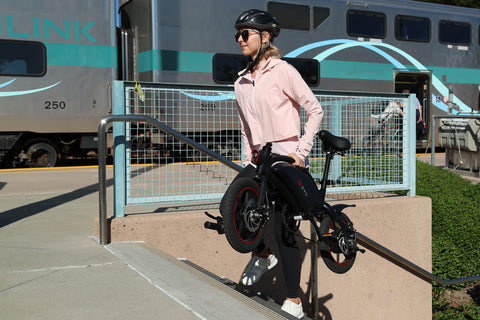 Donna che porta in spalla una bicicletta elettrica D3F DYUcycle.